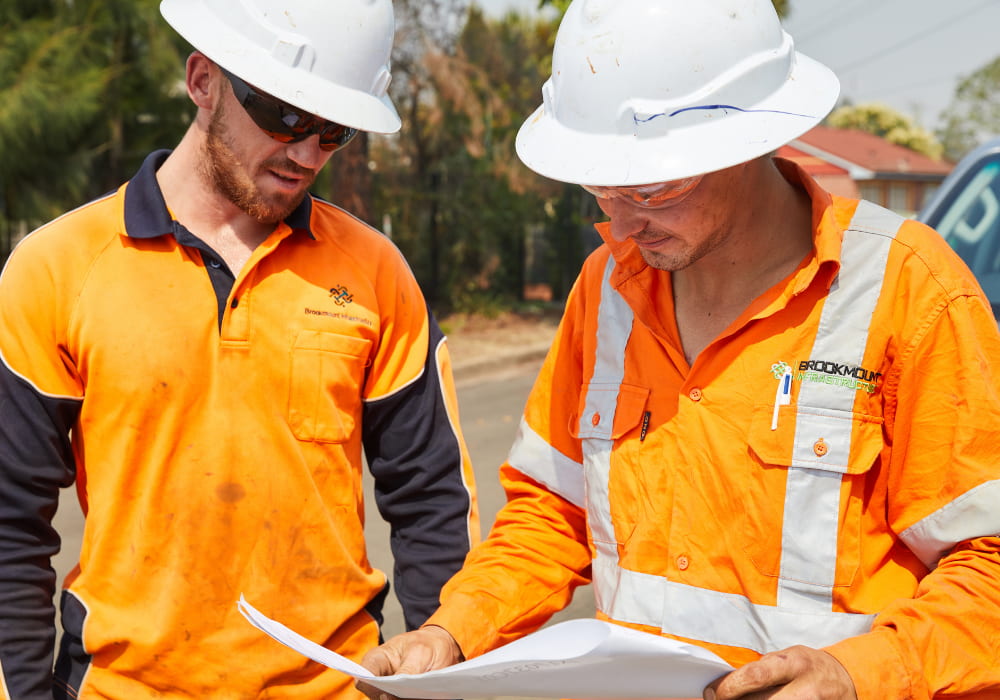 Two workers wearing safety gear discussing project