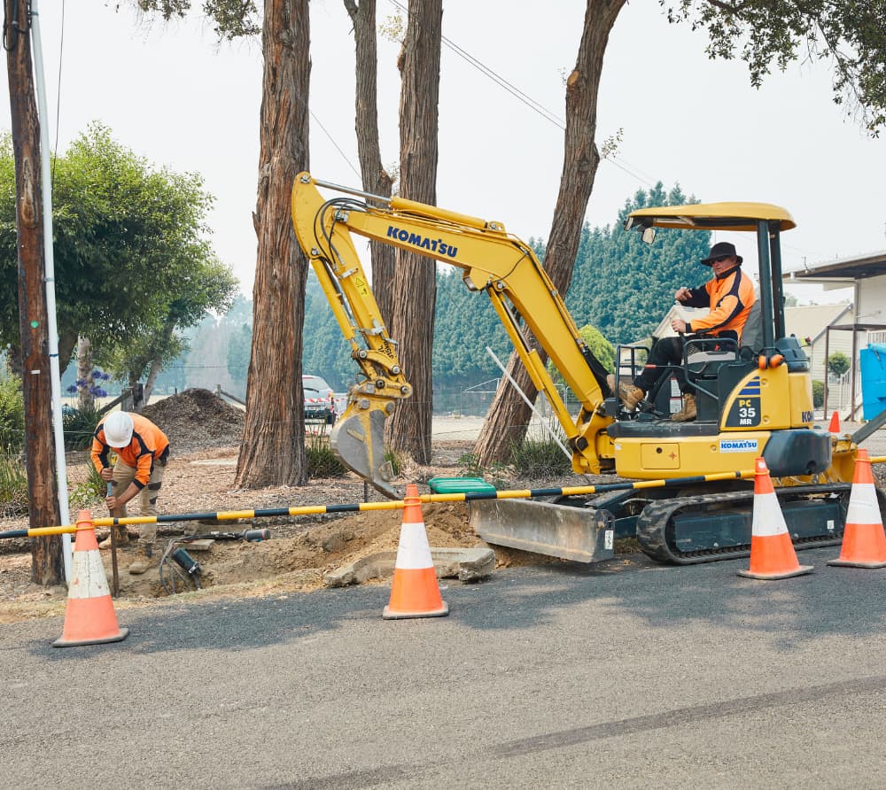 Man using the excavator helping his co worker