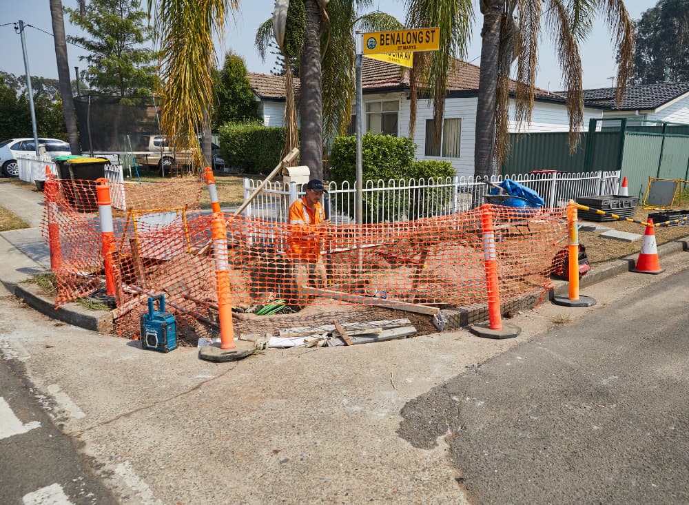 Man digging in the corner of the street