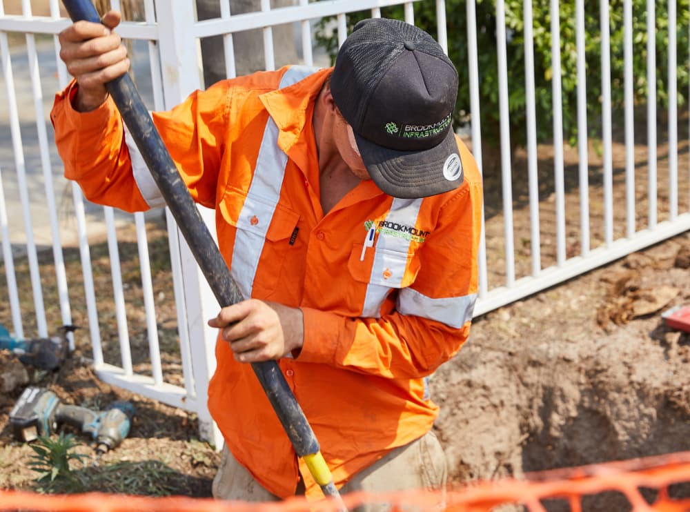 Worker digging with long metal