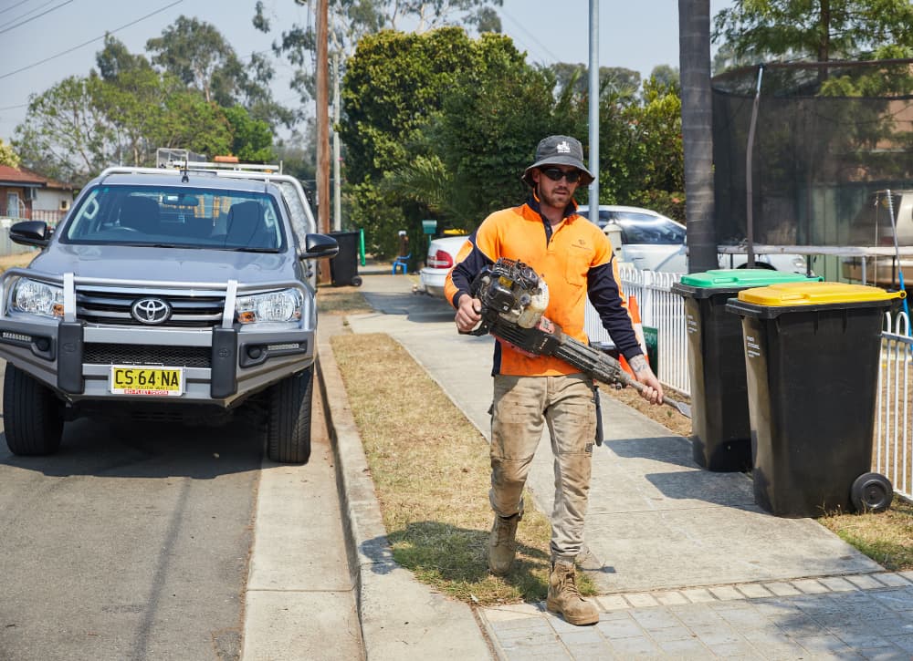 Man wearing a hat carrying a jackhammer